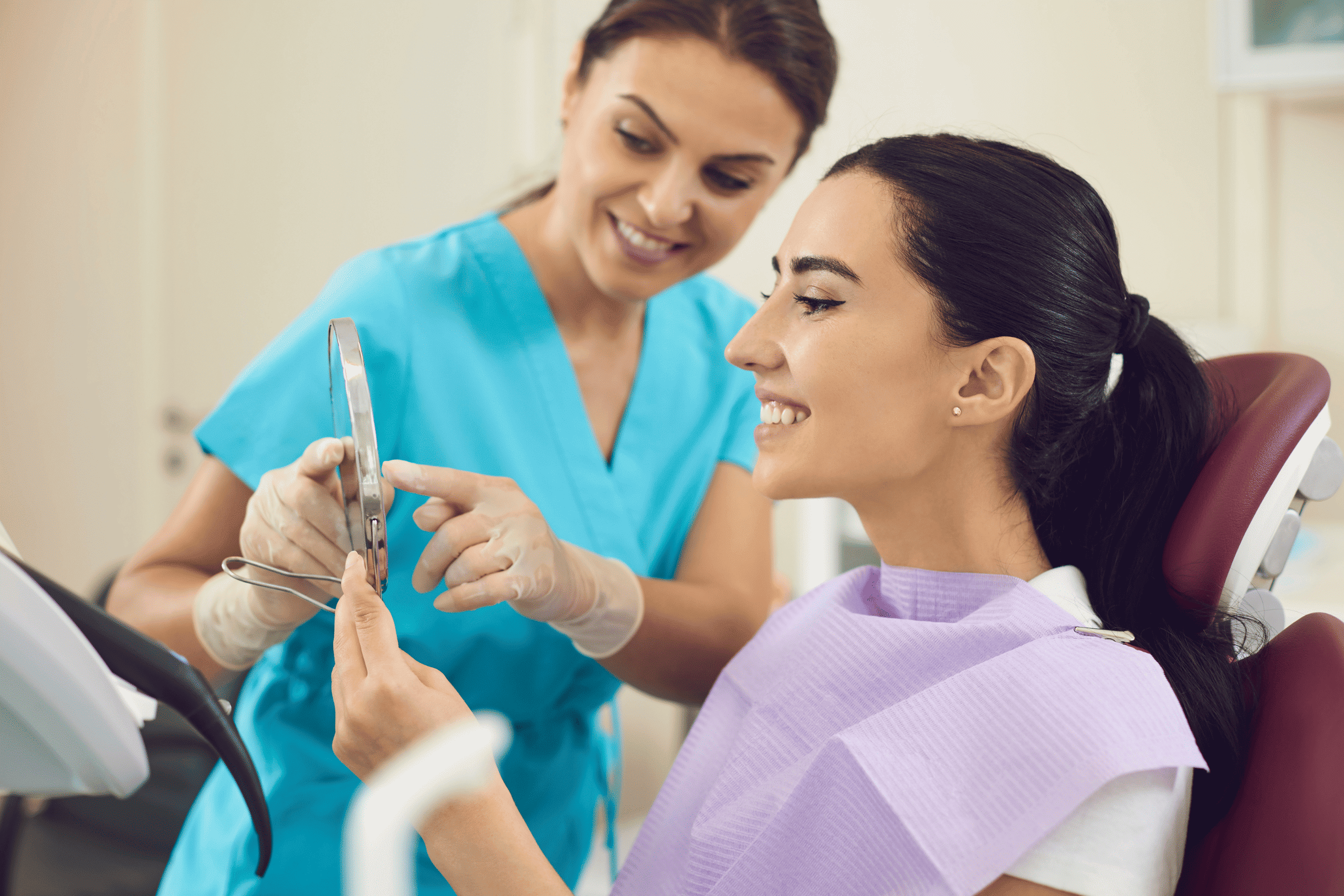Dental hygienist showing a patient their teeth using a mirror, emphasizing personalized care and patient involvement in oral health at Ashar Dentistry.