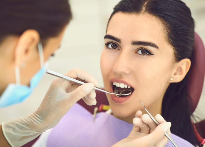 Dentist examining a patient’s teeth with dental instruments in a modern dental office setting, highlighting restorative care and operative dentistry at Ashar Dentistry.