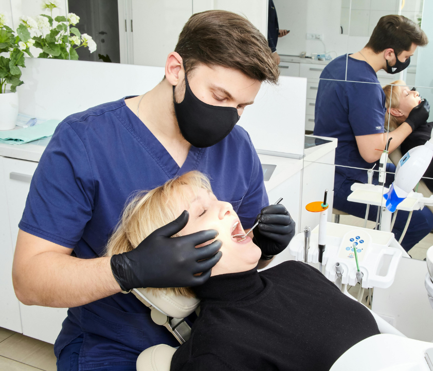 Dentist providing cosmetic dental treatment to a patient in a modern clinic, focusing on personalized care and advanced techniques for smile enhancement.